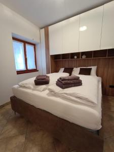 a bedroom with a large bed with towels on it at Residenza dentro le mura in Tirano