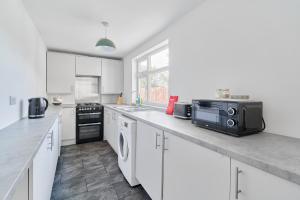 Una cocina con gabinetes blancos y encimera. en Waverley House, en Hartlepool 4 fotos más