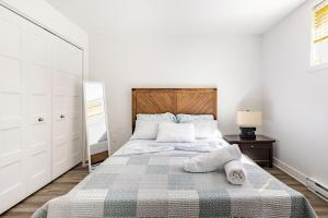 a bedroom with a large bed with a wooden headboard at Logement neuf, spacieux in Longueuil
