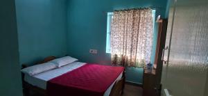 a bedroom with a bed with a pink blanket and a window at B Pool Villa in Yercaud