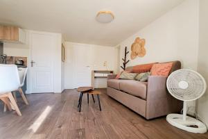 ein Wohnzimmer mit Sofa und Tisch in der Unterkunft Cozy 1BR in the heart of the old village of Villeneuve-Loubet - BENAKEY in Villeneuve-Loubet