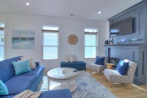 Una sala de estar con un sofá azul y sillas. en Inlet Escape, en Myrtle Beach