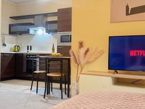 un salon avec une cuisine et une télévision dans l'établissement Apartament Wojskowa 3, à Poznań 6 autres photos