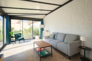 ein Wohnzimmer mit Sofa und Tisch in der Unterkunft Le Relais d'Ezy - 3 chambres in Ézy-sur-Eure + 27 Fotos