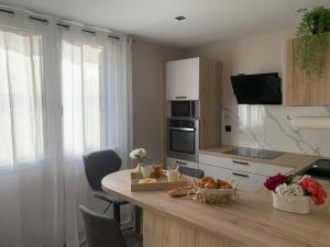 a kitchen with a table and a counter top with a counter top at Le Golden in Valence