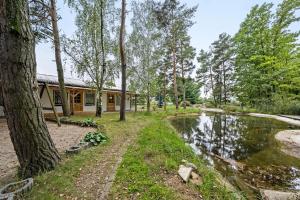 a cabin in the woods next to a pond at Bungalow 20 - Kimbucht in Reichendorf