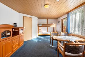 a room with a table and chairs and a bedroom at Bungalow 20 - Kimbucht in Reichendorf