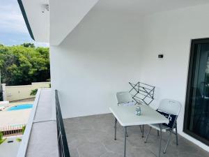a patio with a white table and chairs and a pool at Refresh Holidays in Mont Choisy