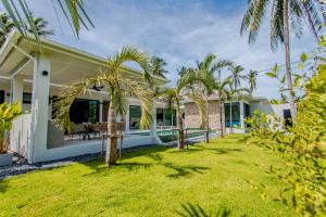 una casa con palmeras en el patio en Villa MAÏA, en Koh Samui 