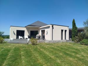 a white house with a lawn in front of it at Parenthèse contemporaine - Élégance et nature in Parigné-lʼÉvêque