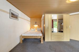 a small bedroom with a bed and a cabinet at Bungalow 22 - Kimbucht in Reichendorf