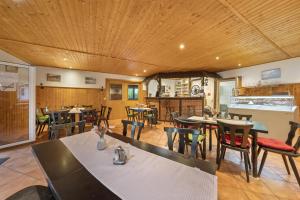 a restaurant with wooden ceilings and tables and chairs at Bungalow 22 - Kimbucht in Reichendorf