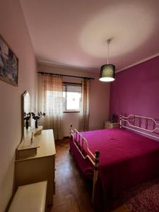 a bedroom with a purple bed and a desk at Apartamento Praia da Barra in Gafanha da Nazaré