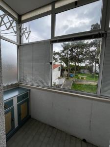 an empty room with a large window with blinds at Apartamento Praia da Barra in Gafanha da Nazaré