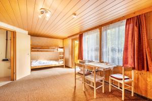 a room with a table and chairs and a bed at Bungalow 23 - Kimbucht in Reichendorf