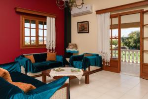 a living room with red walls and blue couches at Selini Suite 2nd floor Panoramic Vineyard Views in Kallithea