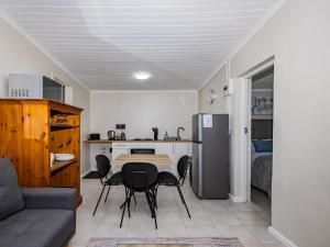 a living room with a table and chairs and a kitchen at Urban Oaks in Bellville