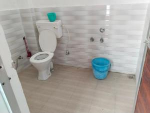 a bathroom with a toilet and a blue bucket at Omkar Homestay in Prayagraj