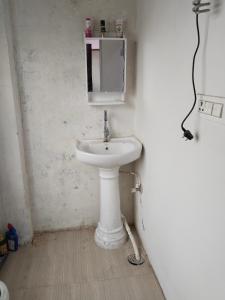 a bathroom with a white sink and a mirror at Omkar Homestay in Prayagraj