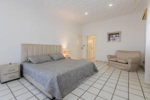 a bedroom with a bed and a chair and a couch at Zenitude Villa Moroccan style and quiet neighborhood in Agadir