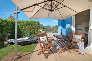 a patio with a table and chairs under an umbrella at Residence Blumar Jesolo Golf Club in Lido di Jesolo