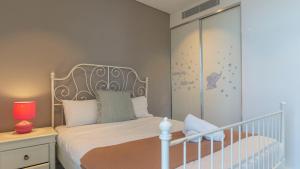 シドニーにあるLeafy Retreat Spacious 2B Penthouse 1 Parkingのベッドルーム(白いベッド1台、ベビーベッド付)