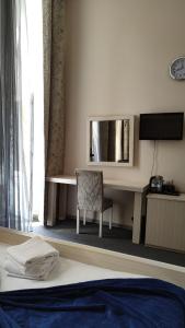 Una habitación de hotel con un escritorio y un espejo. en Sea View Apartments Baku, en Baku