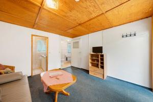 a living room with a table and a couch at Bungalow 28 - Kimbucht in Reichendorf