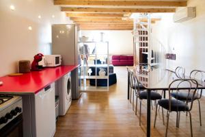 eine Küche mit einer roten Theke und einem Tisch und Stühlen in der Unterkunft Triplex sur les hauteurs de Divonne in Divonne-les-Bains + 13 Fotos