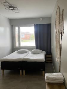 een slaapkamer met een groot bed met een raam bij Viihtyisä esteetön saunallinen asunto entisellä paloasemalla in Sievi