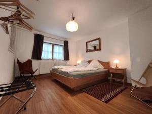 Un dormitorio con una cama y un escritorio y una ventana. en Haus H Stangassinger Apartments, en Berchtesgaden