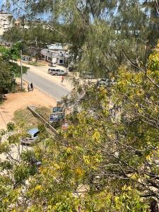 a view of a street with cars parked on the road at holm's home studio in Diani Beach +12 photos