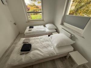 two beds in a small room with a window at FEWO FFM str in Kassel
