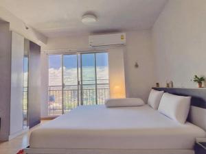 a white bed in a room with a large window at Supalai Mare Pattaya & City Center in Pattaya South +46 photos
