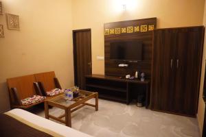 a living room with a television and a table at Bagh mahal by jungle vibes in Sawāi Mādhopur