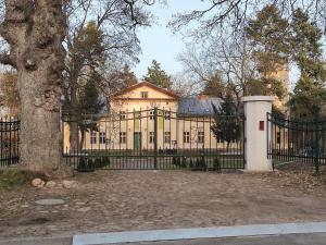 a large house with a black gate and a tree at Palac Kursko Agroturystik in Kursko