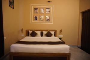 a bedroom with a large white bed with pictures on the wall at Bagh mahal by jungle vibes in Sawāi Mādhopur