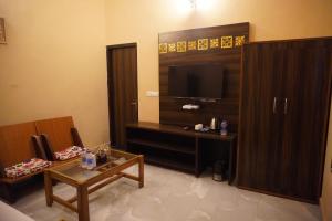 a living room with a television and a coffee table at Bagh mahal by jungle vibes in Sawāi Mādhopur