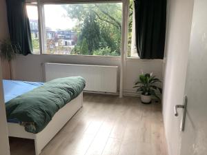 une chambre avec un lit et une grande fenêtre dans l'établissement Cricri, à Lelystad