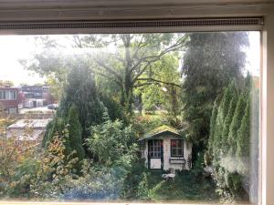 une fenêtre avec une petite maison dans un jardin dans l'établissement Cricri, à Lelystad