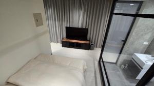 a small room with a bed and a television at C House 角屋 in Hsinchu City