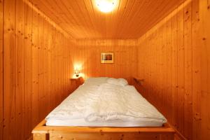 ReichendorfにあるBungalow 34 - Kimbuchtの木製の壁の木製の部屋のベッド1台