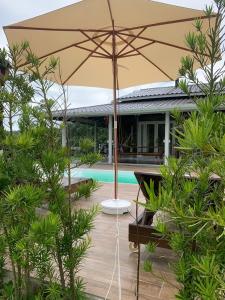 a patio with an umbrella in front of a house at Cabana Guimarães in Rancho Queimado