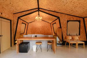 Una habitación con una mesa y taburetes en una tienda de campaña. en The X10 private pool villa khaoyai SHA Certified เขาใหญ่, en Ban Tha Chang