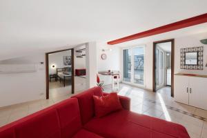 a living room with a red couch and a kitchen at Wohnung Am Gardasee Mit Seeblick No in Bardolino
