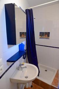 baño con lavabo y cortina de ducha azul en Les myosotis, en Bolquere Pyrenees 2000 22 fotos más