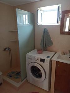 a washing machine in a bathroom with a window at Dimitra's Little House in Petalidhion
