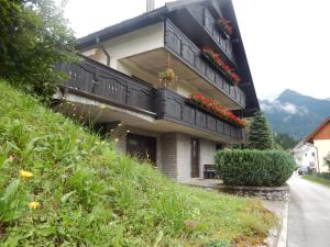 a house with a balcony with flowers on it at Apartment Dijak in Bohinj