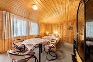 una stanza con due tavoli e sedie in una stanza di legno di Bungalow 12 - Kimbucht a Reichendorf