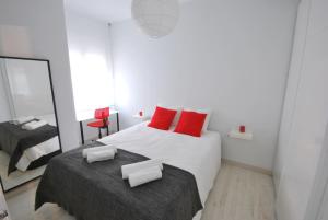 バルセロナにあるArgentona SDBのベッドルーム1室(赤い枕と鏡付きのベッド1台付)